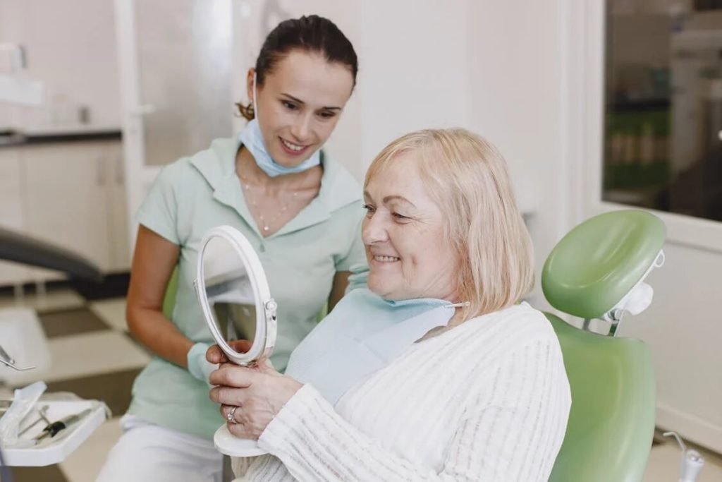 An older woman enthusiastically watches her dentures